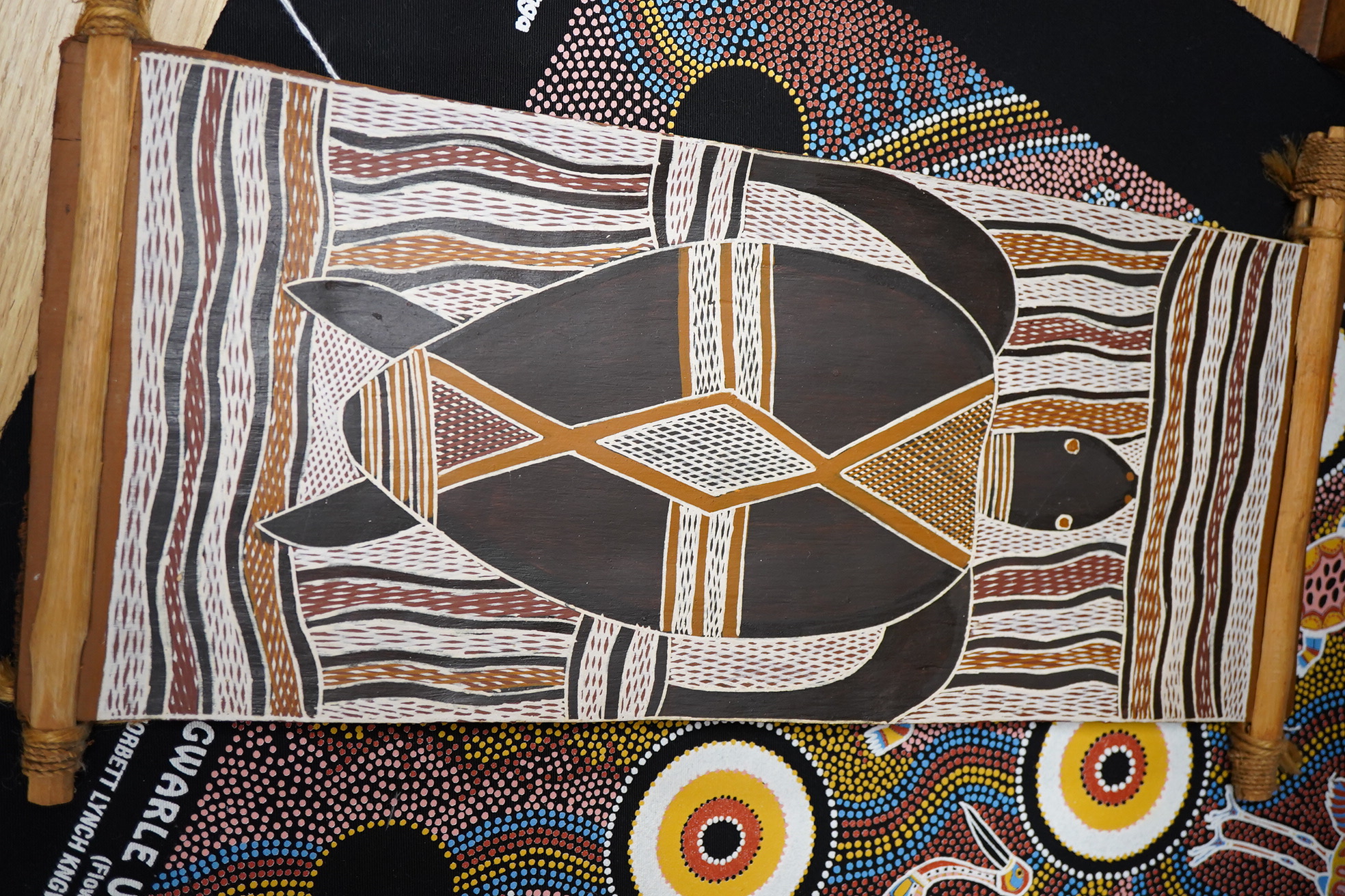 An Aboriginal painted wooden shield and a dot painted scroll